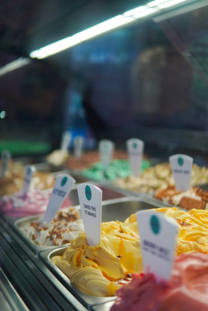 Vibrant variety of ice cream flavors displayed in a dessert shop. Perfect for summer treats.
